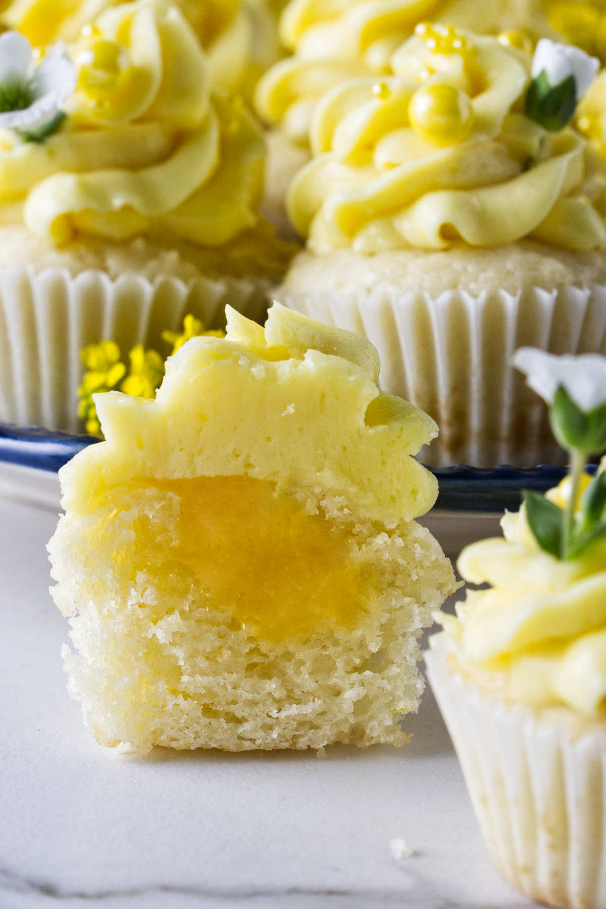 A lemon cupcake sliced in half and showing lemon curd filling.
