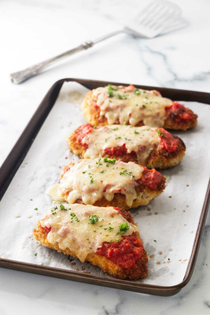 Baked Olive Garden chicken parmesan on a sheet pan.