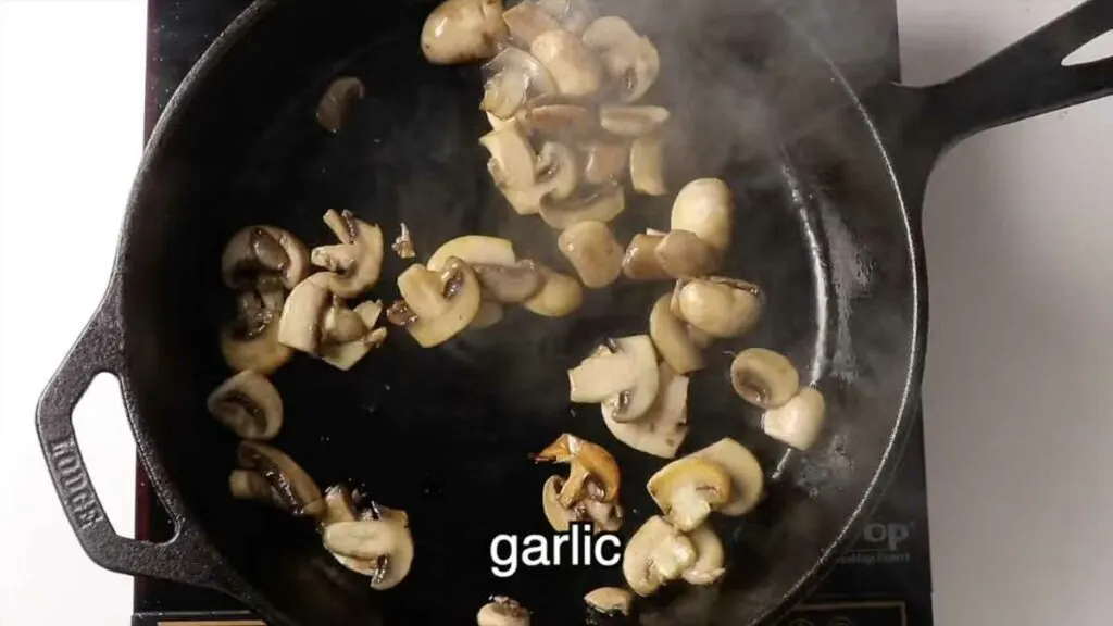 Sautéing mushrooms in a saucepan.