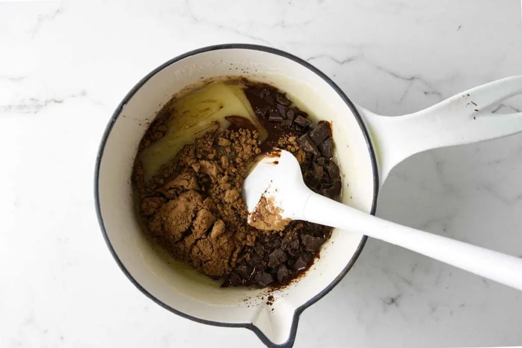 Mixing cocoa and chocolate into the butter and sugar mixture.