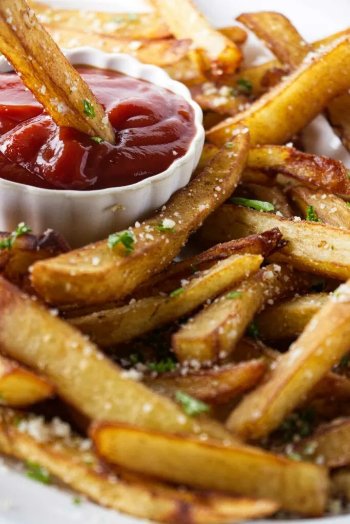 Dipping truffle oil fries in a dish of ketchup.