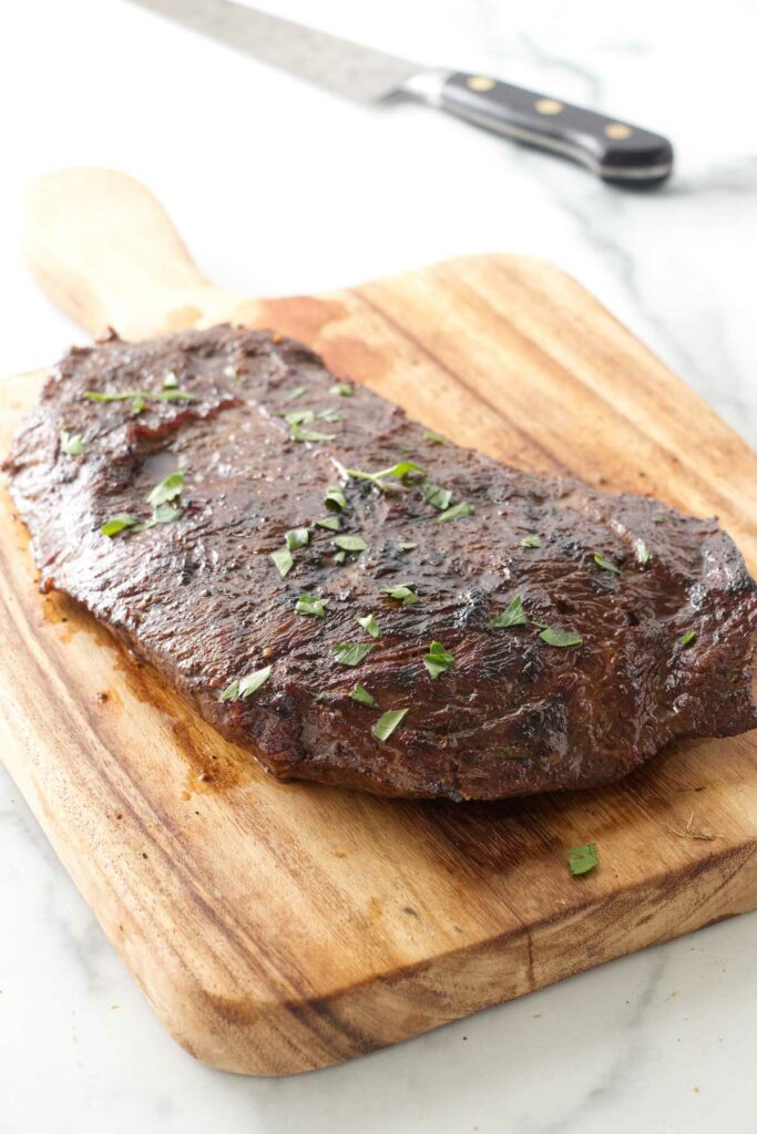 Seared sous vide flat iron steak on a cutting board.