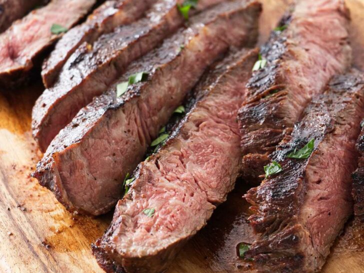 Sliced sous vide flat iron steak on a cutting board.