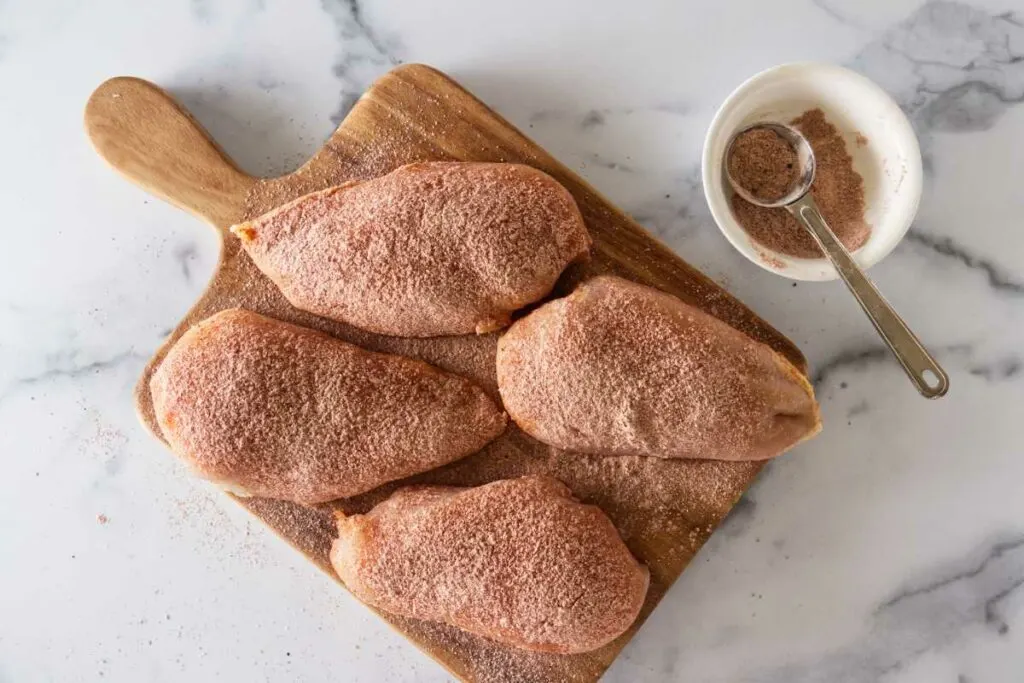 four chicken breasts coated with a mixture o paprika, salt, pepper and flour.