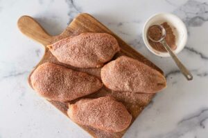 four chicken breasts coated with a mixture o paprika, salt, pepper and flour.
