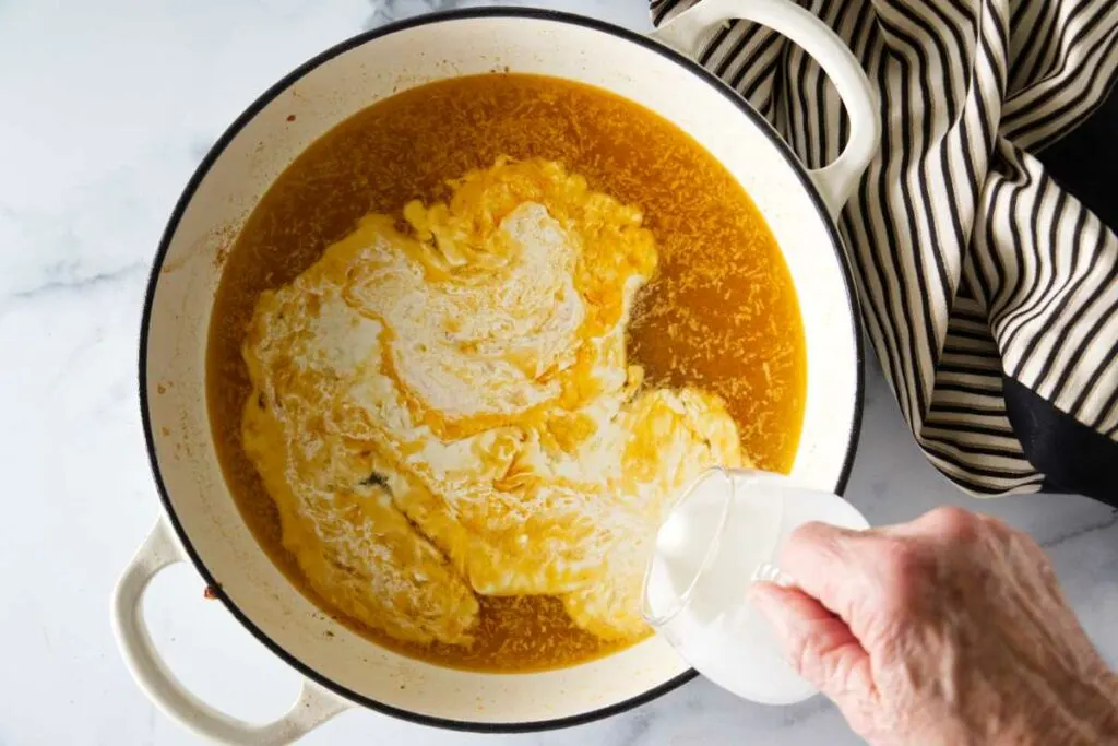 Pouring cream into a pan.