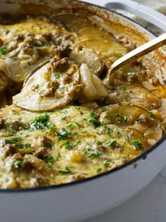 Scooping a serving of hamburger potato skillet bake.