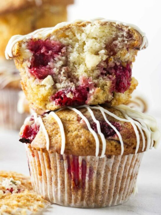 Two strawberry white chocolate muffins stacked on top of each other.