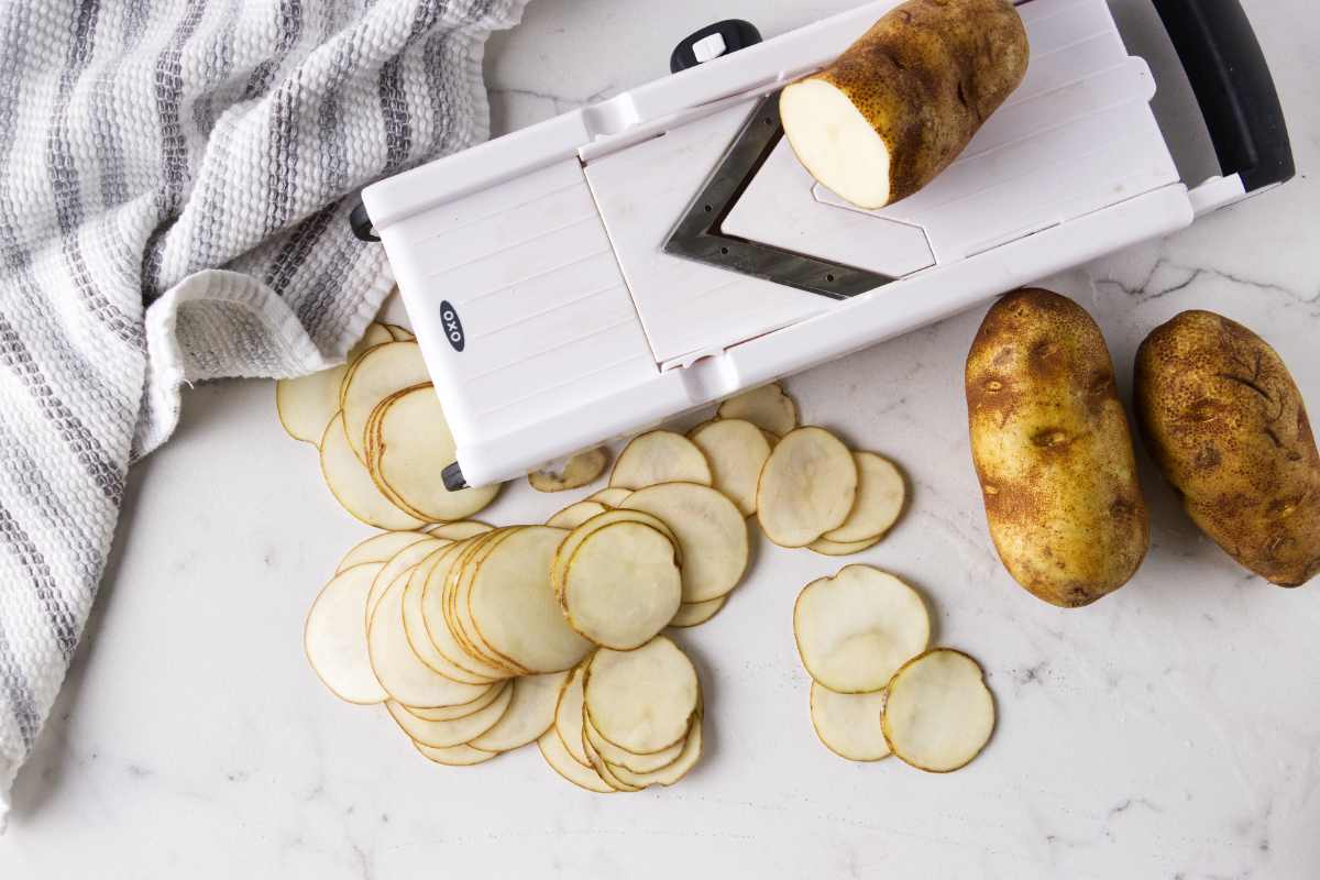 Slicing potatoes with a Mandoline slicer.