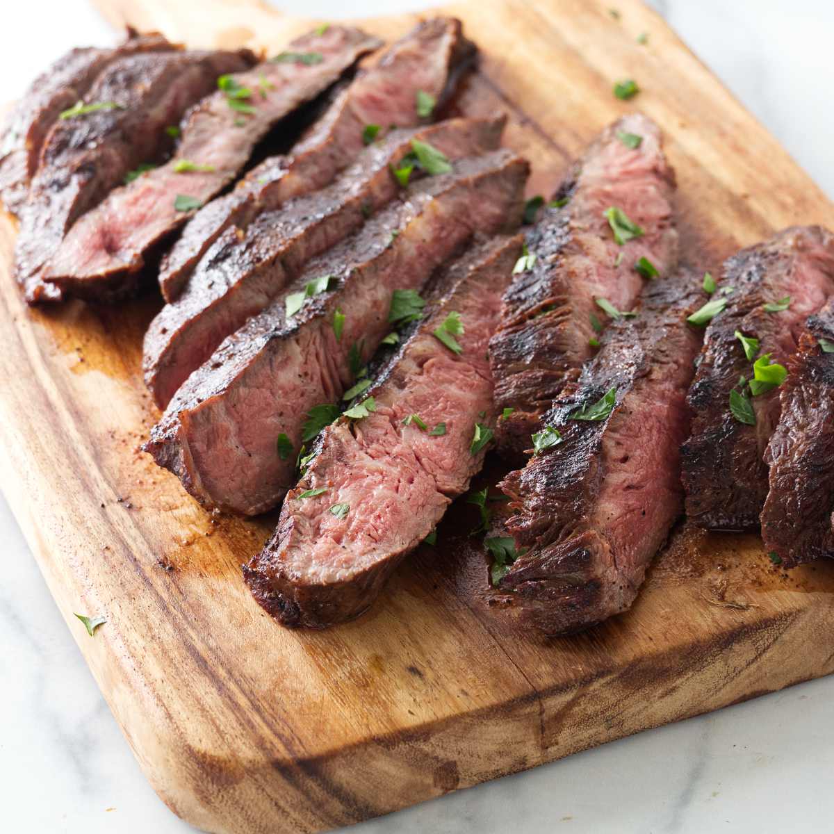 Sliced flat iron steak on a cutting board.