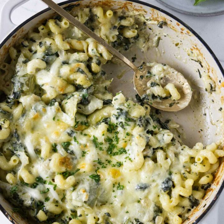A spinach artichoke pasta bake in a skillet.