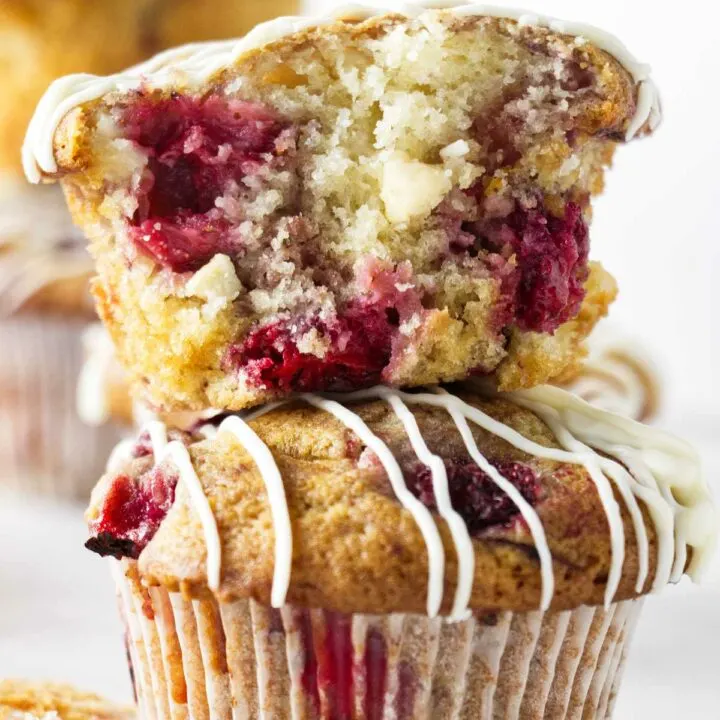 Two strawberry white chocolate muffins stacked on top of each other.