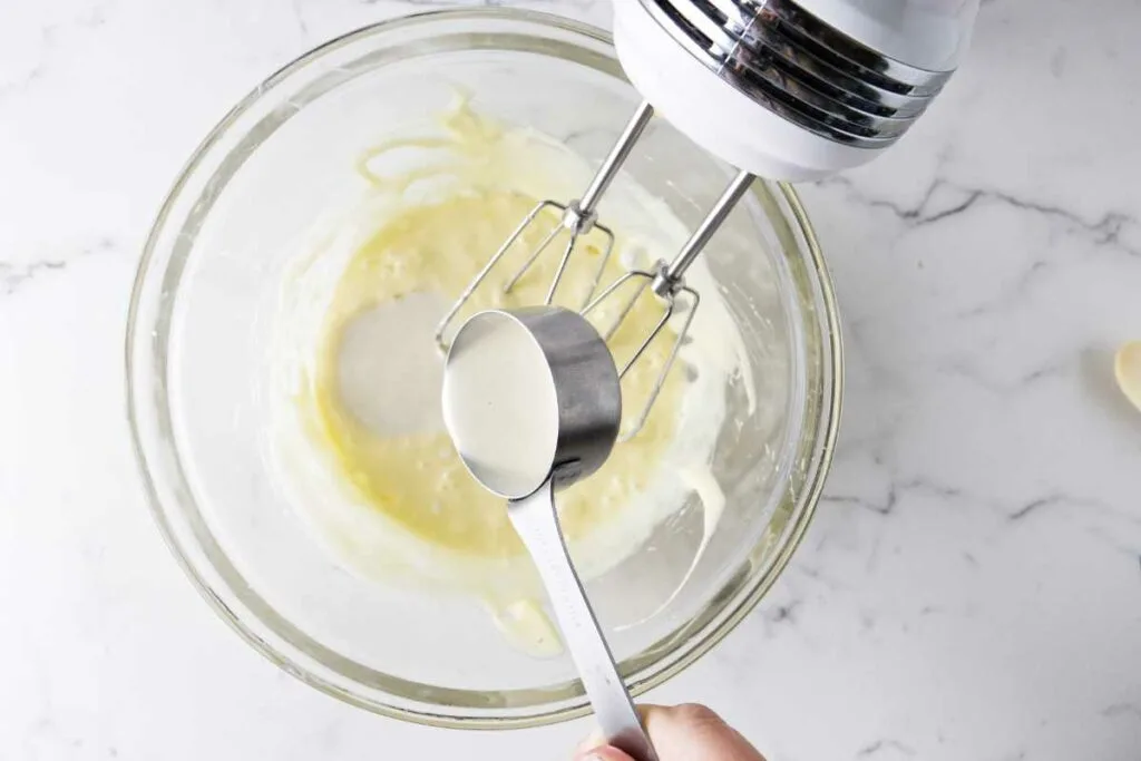 Adding sourdough discard to a mixing bowl.