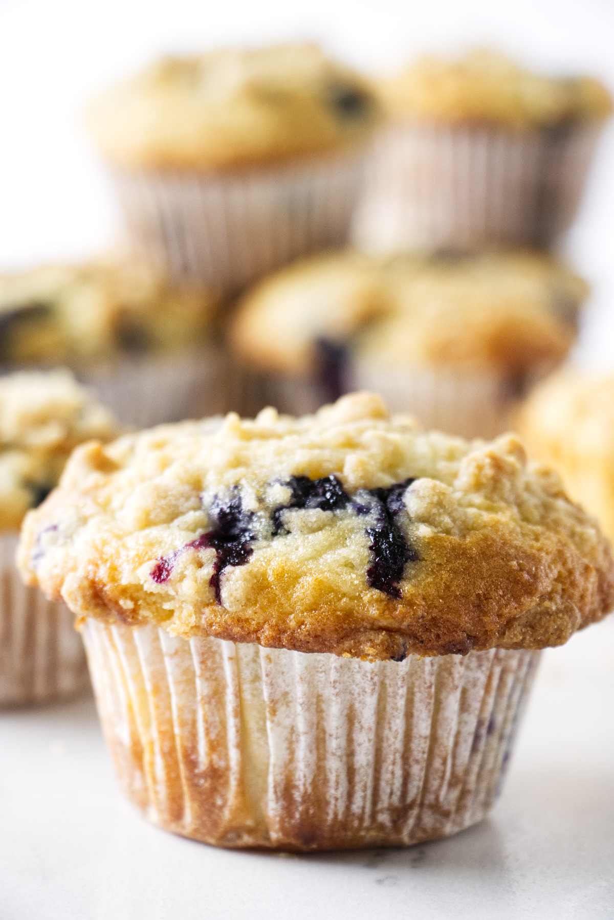 Sourdough blueberry muffin with a stack of muffins in the background.