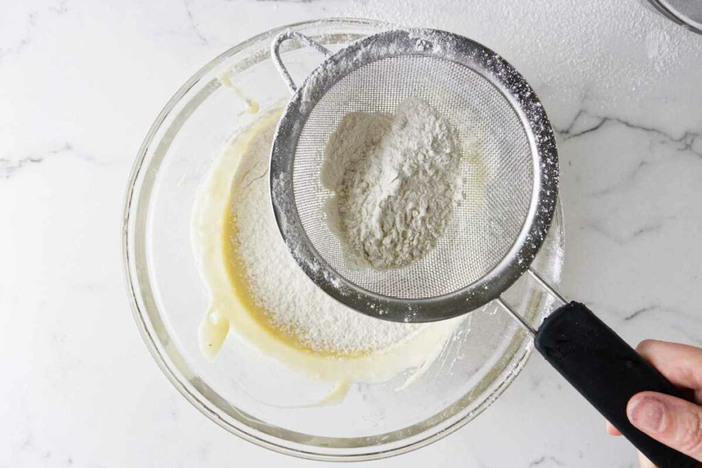 Sifting flour into muffin batter.