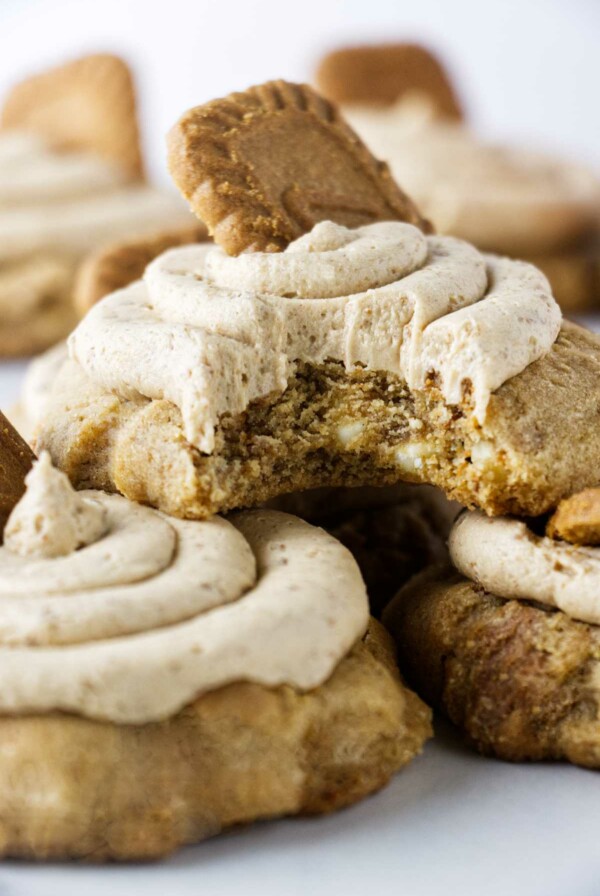 A partially eaten biscoff buttercream cookie stacked on two large cookies.