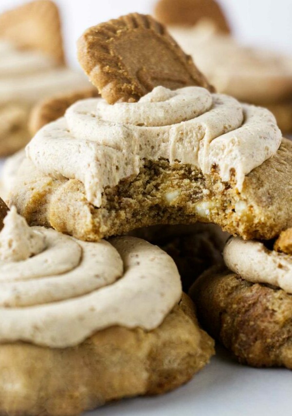 A partially eaten biscoff buttercream cookie stacked on two large cookies.