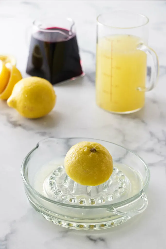 Juicing lemon halves on an old fashioned lemon juicer.