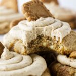 A partially eaten biscoff butter cookie topped with a swirl of biscoff buttercream.