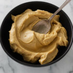 A bowl of blended white miso and butter with a spoon.