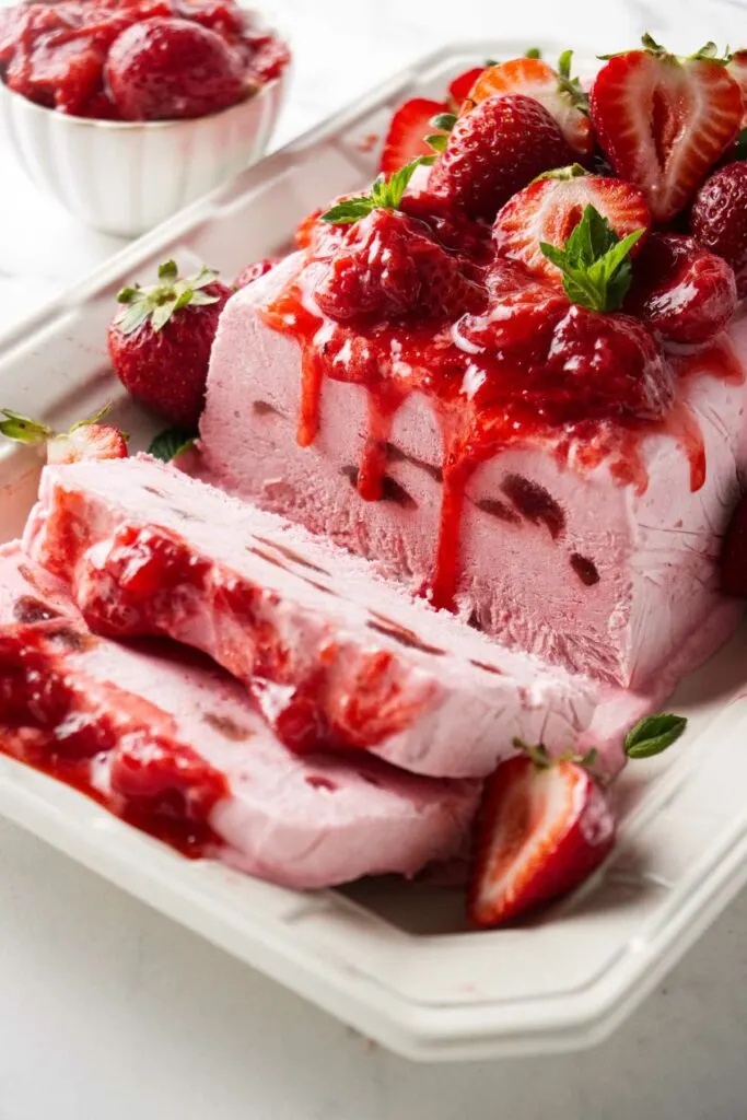 Strawberry semifreddo with swirls of strawberry jam and strawberry sauce.