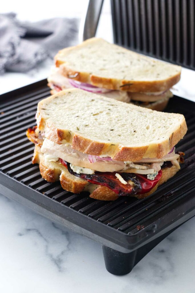 Two sandwiches on a panini grill.