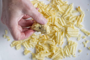 Rolling cookie dough in crushed potato chips.
