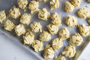 Placing balls of cookie dough an a tray.