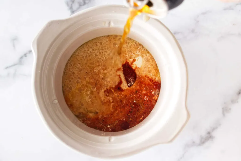 Pouring beer into a small crock pot.