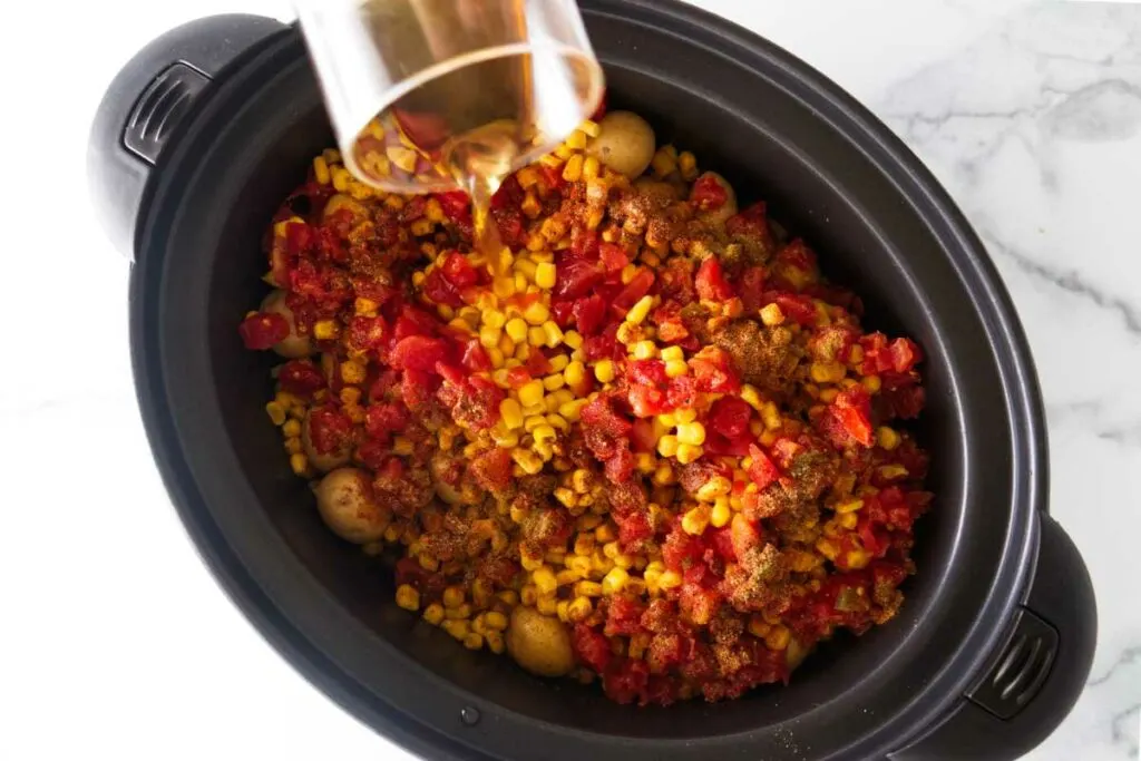 Pouring broth into the crockpot.