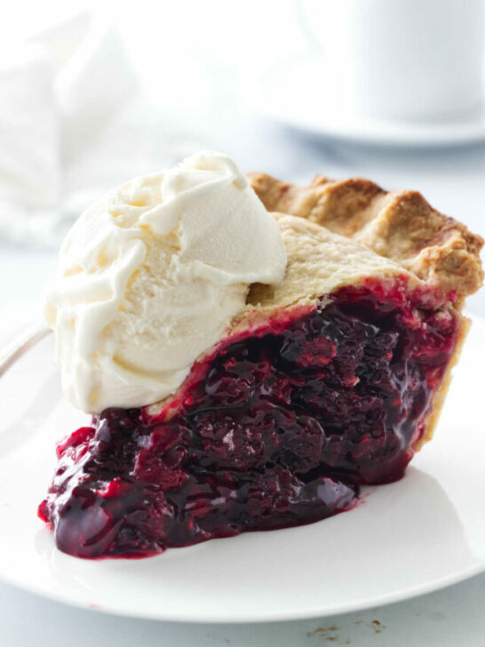 A plate with a slice of berry pie and a scoop of vanilla ice cream.