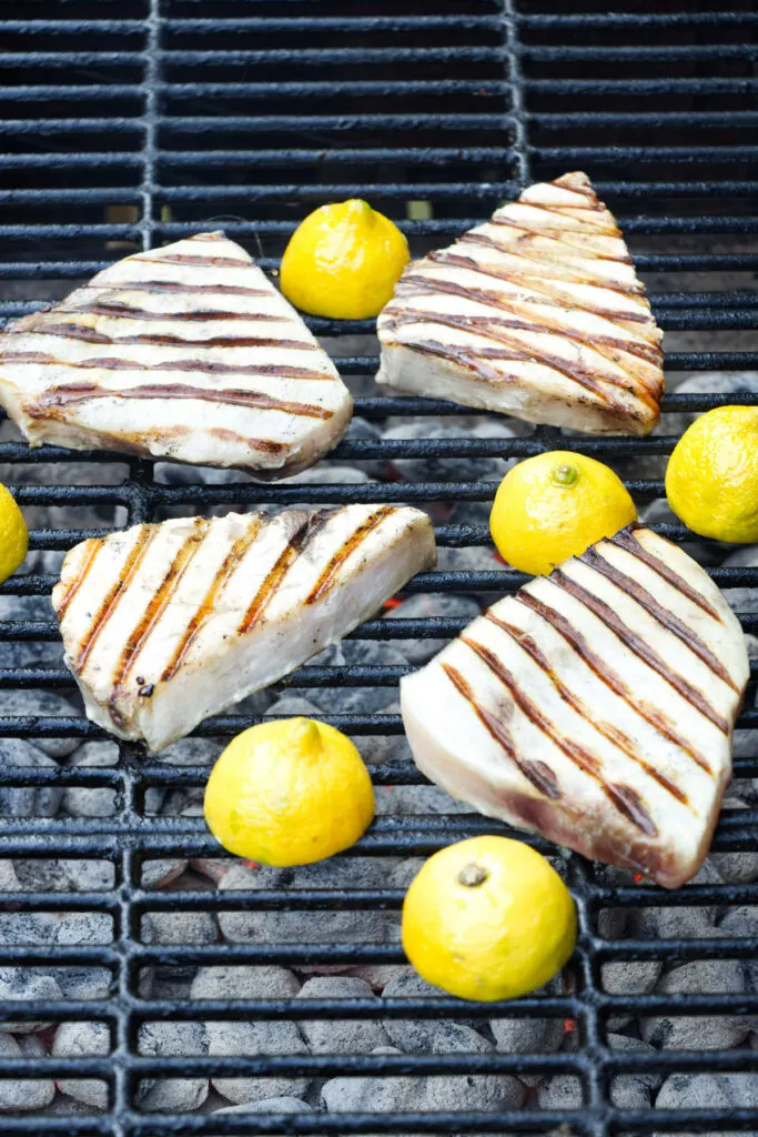 Four swordfish filets on a grill.