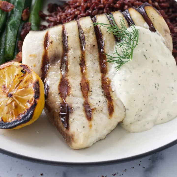 Grilled swordfish on a white plate.