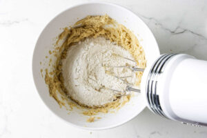 Mixing the flour mixture into the creamed sugar and butter mixture.