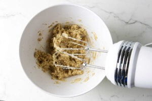 Creaming sugar and butter with an electric hand mixer.