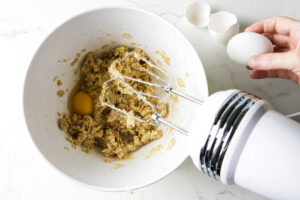 Adding the eggs to the creamed sugar and butter.