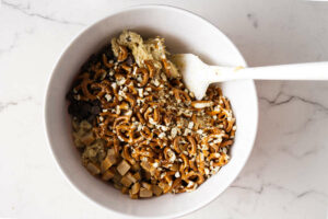 Mixing pretzels and caramel chunks into chocolate chip cookie batter.