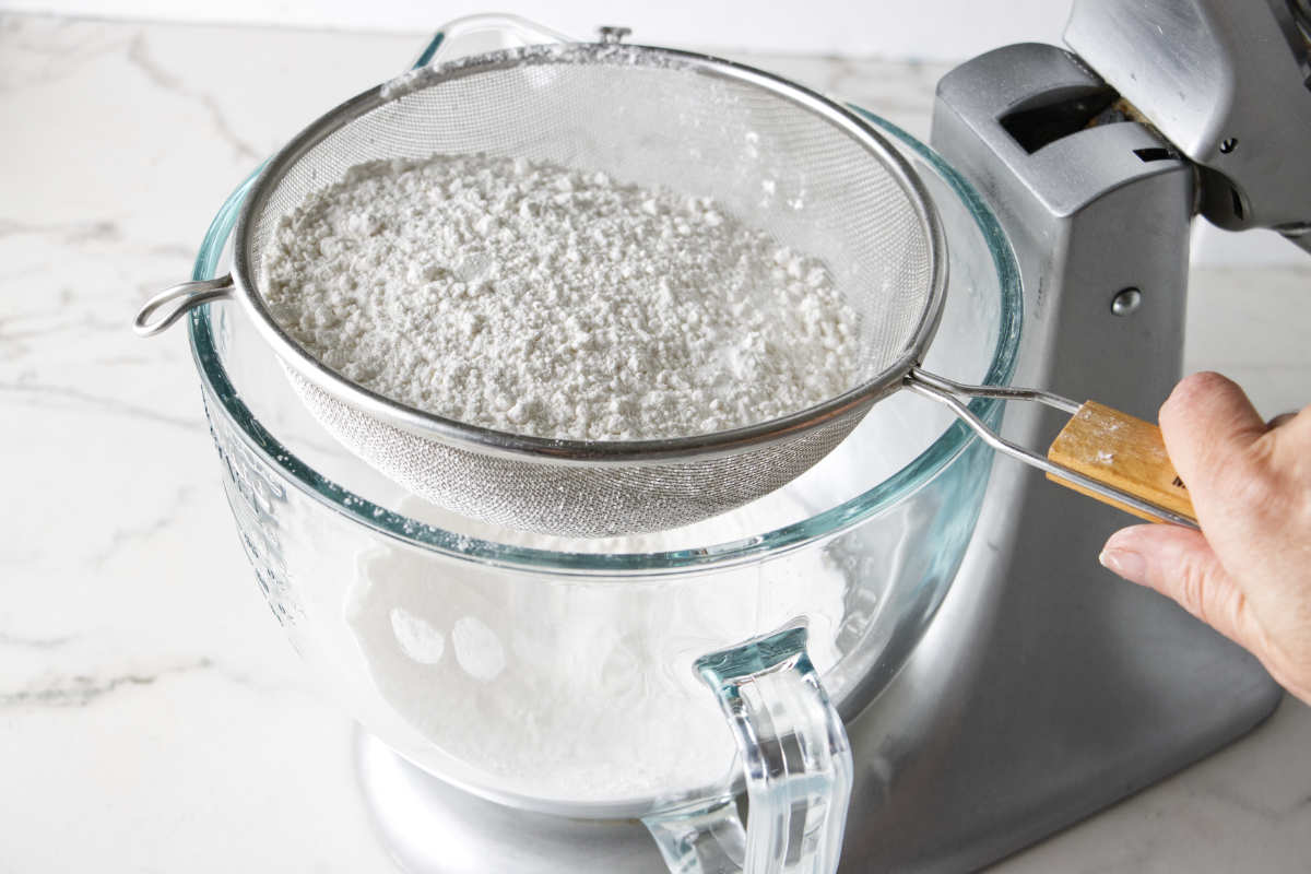 Sifting flour into a mixing bowl. 