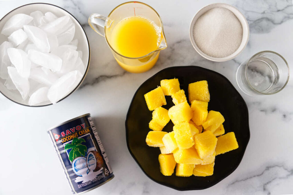 Ingredients to make a non-alchoholic beverage: Ice, pineapple juice, sugar, water, pineapple and coconut cream.