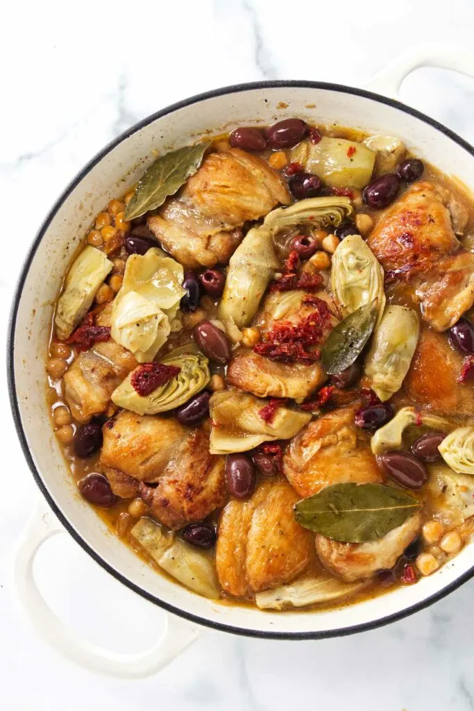 Pot with chicken, artichokes, olives and garbanzo beans ready for serving.