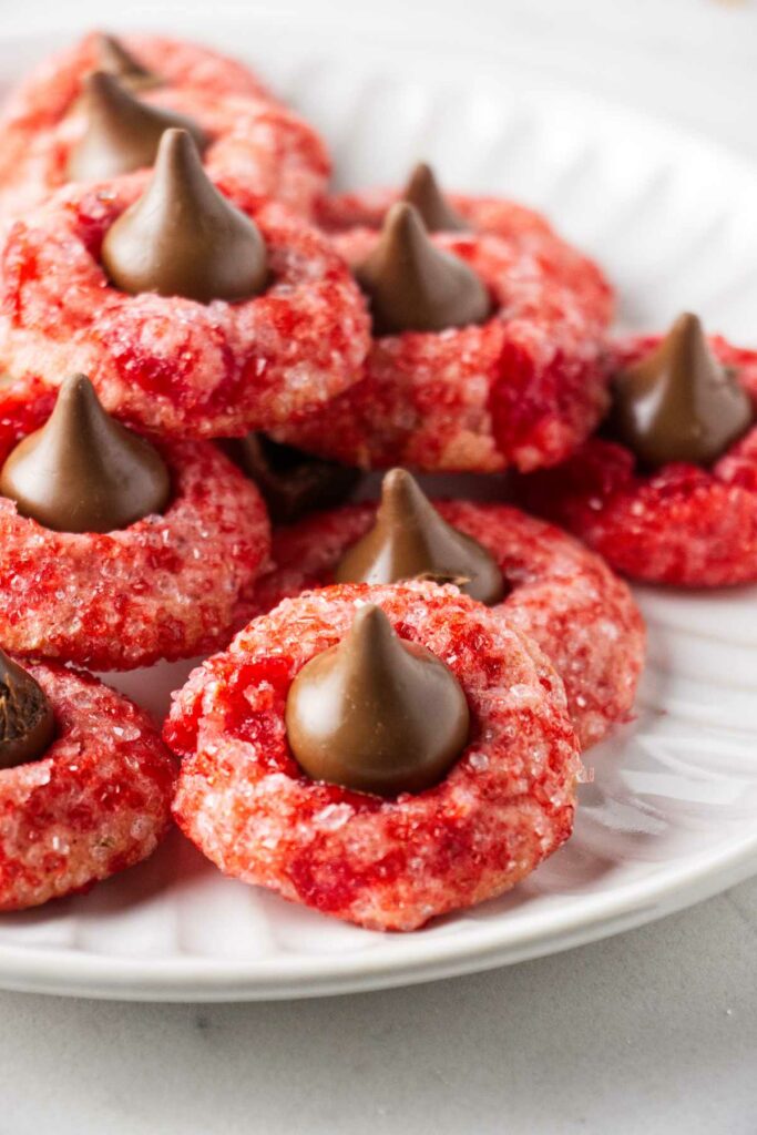 Cherry cookies with Hershey's kisses in the center, stacked on a plate