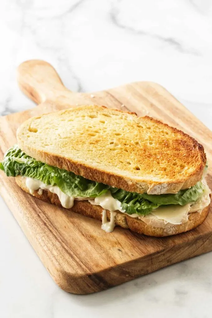 Sandwich on a wooden cutting board.