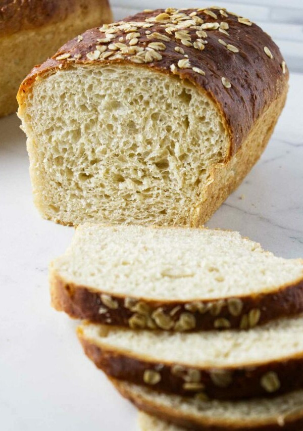 Slices of oatmeal bread in front of a loaf of bread.