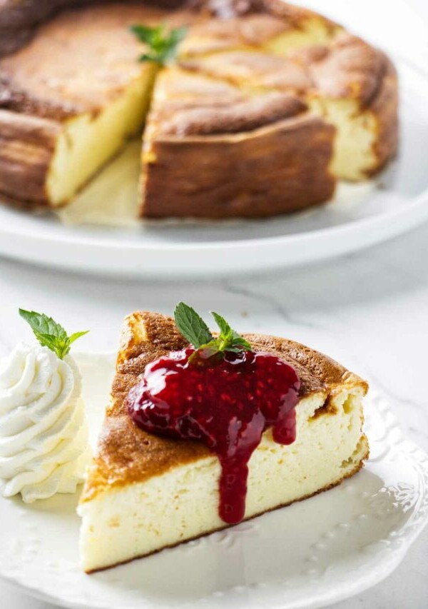 A slice of creamy yogurt cake behind a plate with more cake.