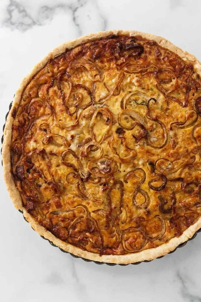 Overhead view of a baked French onion tart in the baking pan.