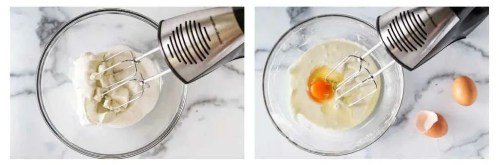 A bowl with sugar and goat cheese with a hand mixer. One egg in a bowl of cheese/sugar mixture with a hand mixer. One egg and one egg shell in the lower right corner.
