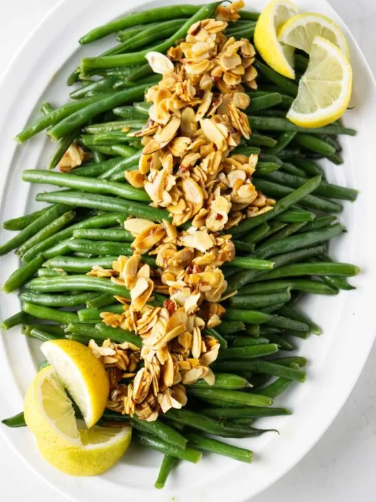 Brown butter green beans with toasted almonds on a serving platter.