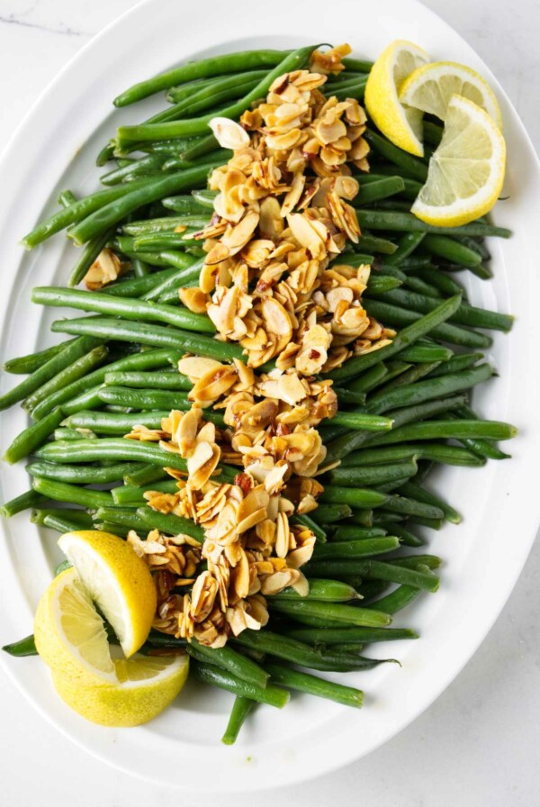 Brown butter green beans with toasted almonds on a serving platter.