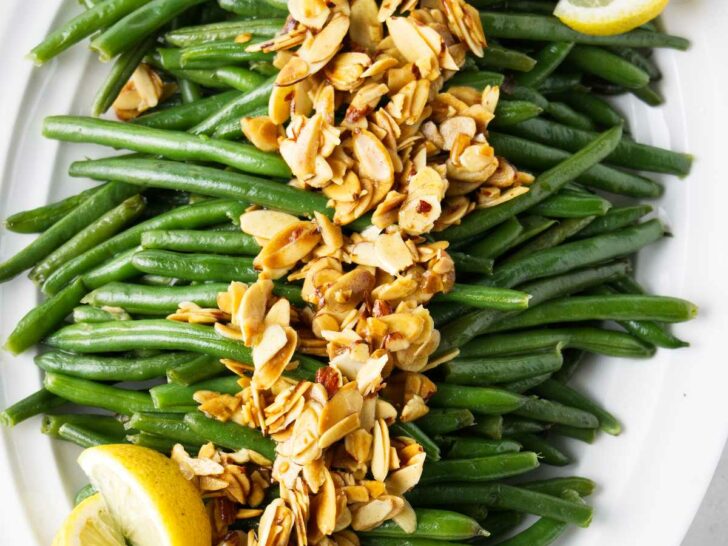 Brown butter green beans with toasted almonds on a serving platter.