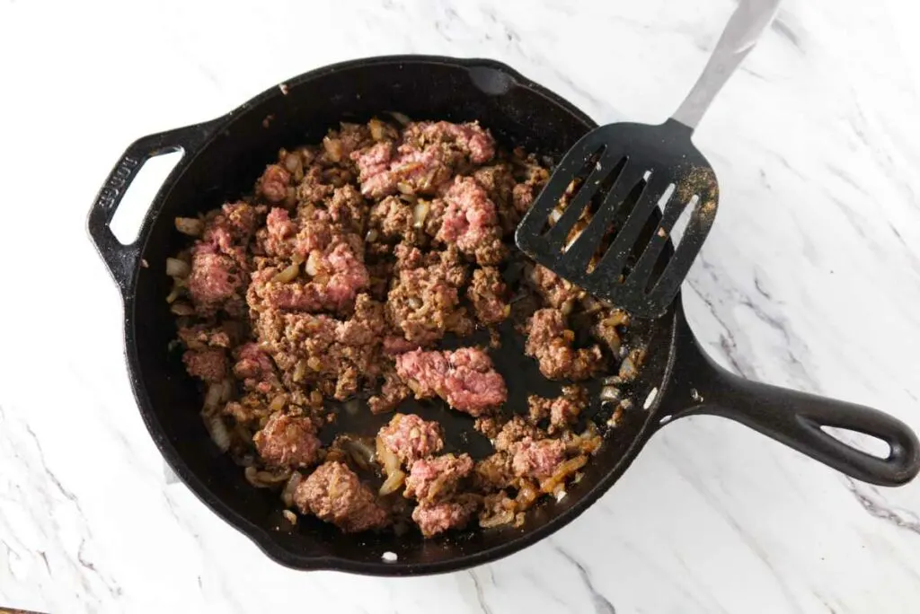 Browning ground beef in a skillet.